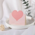 Pink heart-shaped greeting card with Best Wishes text on a white ceramic tray - Pink