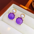 Macro shot of vintage gold earrings with purple gemstone and white pearl in a box - Silver Pin - Purple Stud Earrings