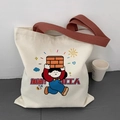 Detail of canvas tote bag showing creative cartoon print and durable brown handles - Hardworking Laborer