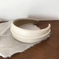 Detail van beige leren hoofdband met elegant stiksel en zachte fluwelen voering - Off-wit