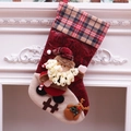 Classic red Christmas stocking with Santa and reindeer dolls on white fireplace - Santa Claus