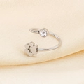 Detail of silver cat paw ring with cubic zirconia on soft champagne silk fabric - US 6