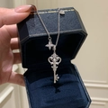 Detailed view of an ornate silver key pendant necklace with a zircon star charm - Silver