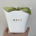 Close-up of white textured gift box with green satin bow and gold merci lettering - 20cm Bow / Olive Green