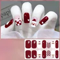 Detail of Christmas gel nail wraps with Santa and red checkerboard patterns - CS430