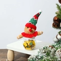 Close-up of knit gingerbread man candy jar on white wooden stand with festive tree decor - Gingerbread Man Candy Box Sharp Hat
