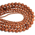 Macro shot of sparkling goldstone round beads arranged in concentric circles by size - Gold Sandstone / 4mm Approx 93pcs