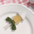 Quirky Oden skewer food hair clip with deep green bow on pink checkered background - Oden Skewer