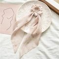 Macro detail of a light pink star chiffon scrunchie with long ribbons on a white plate - Khaki With Gold Stars