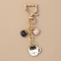 Dettaglio del portachiavi gatto nero in tazza di caffè con chiusura dorata - Rosa