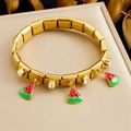 Dettaglio di un bracciale modulare in acciaio dorato con ciondoli anguria in smalto e zirconi - Stile Anguria (B1718)