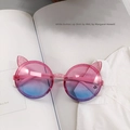 Detail of pink cat-ear sunglasses with glitter frame and gradient lenses on white shirt - Pale Blue