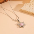 Macro detail of silver sun pendant with pink opal and zircon pavé on snake chain - Pink Zirconia Necklace / Silver
