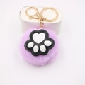 Close-up of purple faux fur pompom keychain featuring a white cat paw and gold clasp - Cat Claw Gold Keychain / Taro Purple