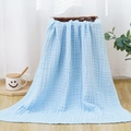 Light blue six-layer cotton gauze baby blanket with waffle texture on a wicker basket - Light Blue