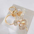 Sparkling clover keychain with colorful crystals and gold metal ring on a clear stand - White