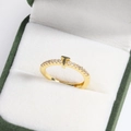 Macro detail of gold T-shape ring with sparkling pavé stones in a green velvet box - Letter T Gold