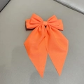 Neon coral chiffon bow hair clip with elegant long streamers on a textured surface - Spring Clips / Orange