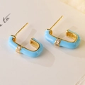 Close-up of gold-plated U-shaped earrings with light blue enamel and zircon inlay - Light Blue
