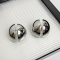 Vue macro de boucles d'oreilles demi-sphères argentées avec finition miroir polie - Type K Boucles d'Oreilles Hémisphère Coupées Argentées
