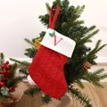 Knitted red Christmas stocking with white cuff and red embroidered letter V detail - Letter V