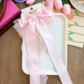Pink oversized bow hair clip with satin ribbons on display card with tulips - Pink