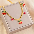 Dettaglio collana a catena dorata con pendenti a ciliegia rossa e perle rosso scuro - Collana