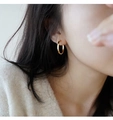 Primer plano de un pendiente de aro dorado pulido llevado para un look elegante y chic - Dorado Par (22mm)
