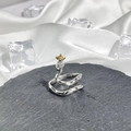 Detail of silver snake ring with clear gemstone head and gold star on stone slab - No. 16 Open Ring