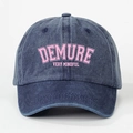 Detail der dunkelblauen gewaschenen Jeans-Basecap mit rosa DEMURE-Stickerei - Marineblau