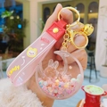 Detailed close-up of a pink moon rabbit acrylic keychain with colorful flowing beads - Pink
