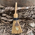 Macro view of a miniature witch broom pendant with triquetra charm and yellow gemstone - 10cm / Straw Broom + Celtic Knot + Random Stone