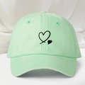 Detailed view of mint green cotton baseball cap with black heart embroidery and eyelets - One Size / Light Green