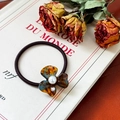 Brown tortoiseshell clover hair tie with center pearl decoration on vintage book - Blue Brown