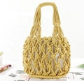 Detail view of yellow hand-woven straw tote bag with beige fabric lining and soft texture - Yellow