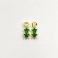 Dettaglio di ciondoli a stella dorati con inserti in zircone verde smeraldo per il DIY - Verde Smeraldo