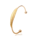 Bohemian style gold-plated open cuff bracelet featuring an intricate feather design - Feather Design / Gold