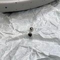 Macro shot of black heart-shaped zircon earring with silver beaded edge detailing - Black