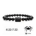 Detailed close-up of matte black agate beads bracelet with golden Cancer zodiac cylinder - Cancer