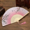 Detail of a Chinese silk folding fan with floral patterns and a pink silk tassel - Pink Peach Blossoms