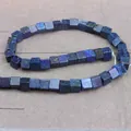 Vista macro de cuentas de lapislázuli natural en forma de cubo con textura azul y pirita - Lapislázuli