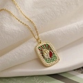 Macro detail of gold tarot pendant with shell motif and colorful enamel inlay - Conch