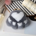 Detailed view of gray and white rabbit fur cat paw charm with a gold-tone keychain hook - Gray