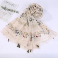 Detail of beige cotton linen scarf with floral patterns and tassels on white background - Style 19