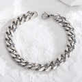 Poliertes silbernes Panzerarmband aus Edelstahl mit Karabinerverschluss auf Steinfläche - Silber