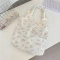 Close-up of cat print canvas tote bag with colorful embroidered label on white desk - Printed Cat White