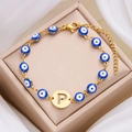 Golden Evil Eye bracelet featuring blue beads and a metallic letter P pendant detail - Letter P
