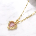 Collier doré avec pendentif cœur, pierre rose et zircon sur fond de marbre - Rose