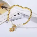 Detail view of a pearl beaded bracelet with a gold teddy bear pendant and micro-pave zircons - Micro Pave Bear