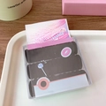 Close-up of baby size black hair elastics in a cartoon-themed transparent cereal box - 40 Pcs/Box / Black